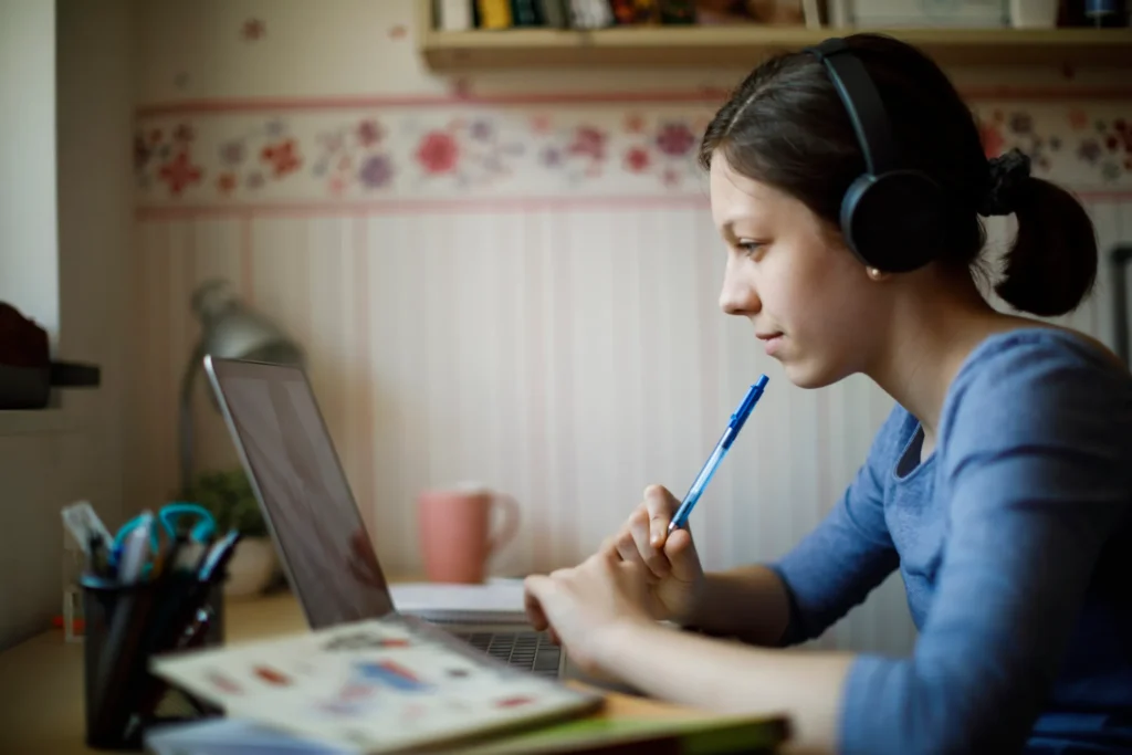 Dziewczynka ucząca się online przy laptopie z nauczycielem podczas korepetycje z biologii